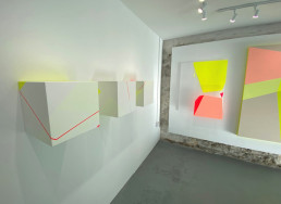 paintings protrude from the wall in a sequence of three cube block canvases in this exhibition by Trudie Moore at Greys Wharf in Penryn Cornwall
